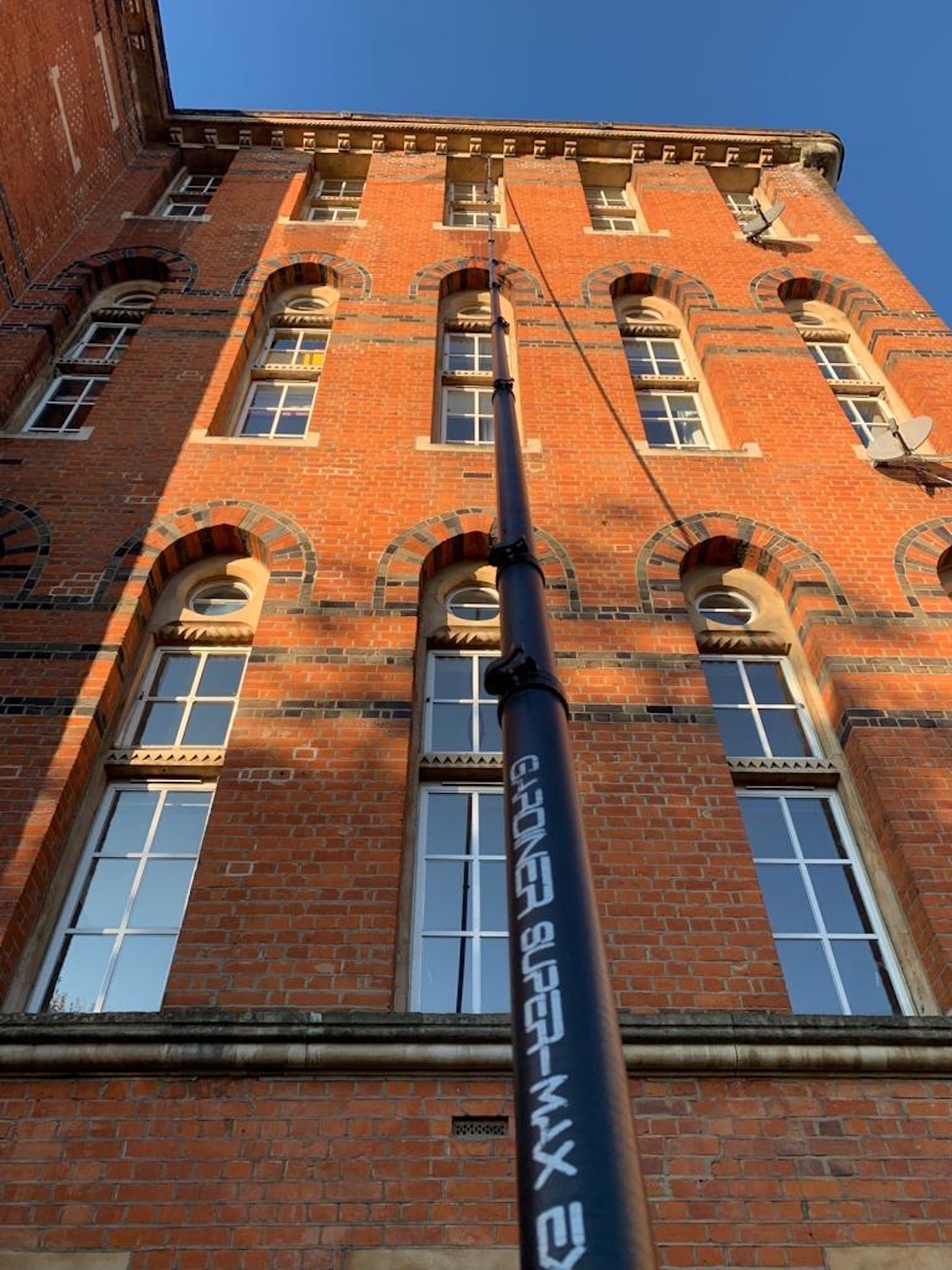 High-level window cleaning on a red brick building in Barnes, SW13